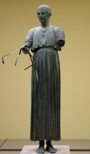 Woźnica z Delf jest ubrany w chiton. Posąg pochodzi z V w p.n.e. przykład tkaniny z lnu